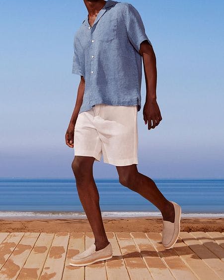 male model in polo and shorts with blue sky background