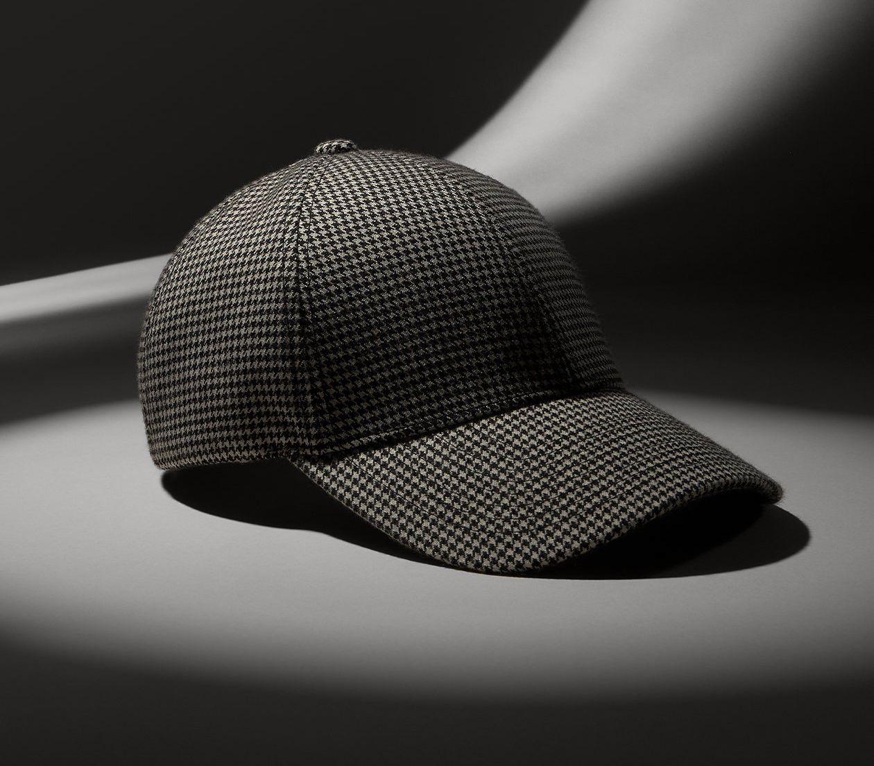 checkered baseball cap displayed on grey backdrop