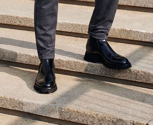 Mannequin masculin en bottes noires sur les escaliers