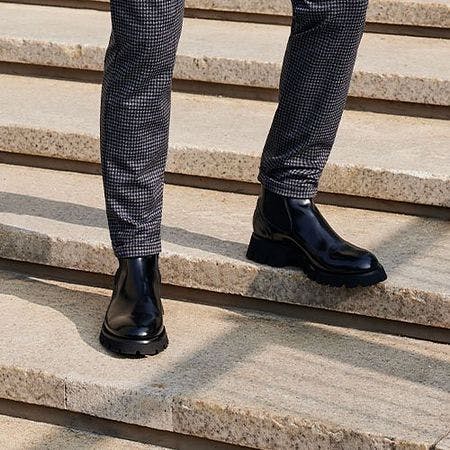 Mannequin masculin en bottes noires sur les escaliers