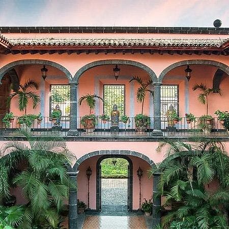 Une cour avec une fontaine et un balcon avec des plantes