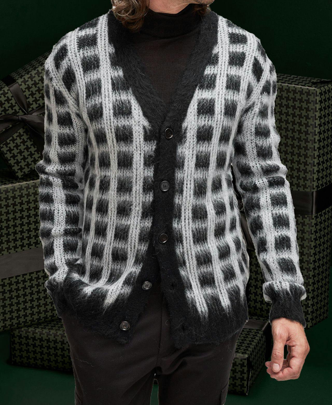 Model displaying Marni Checkered Mohair Cardigan against dark green gift boxes background