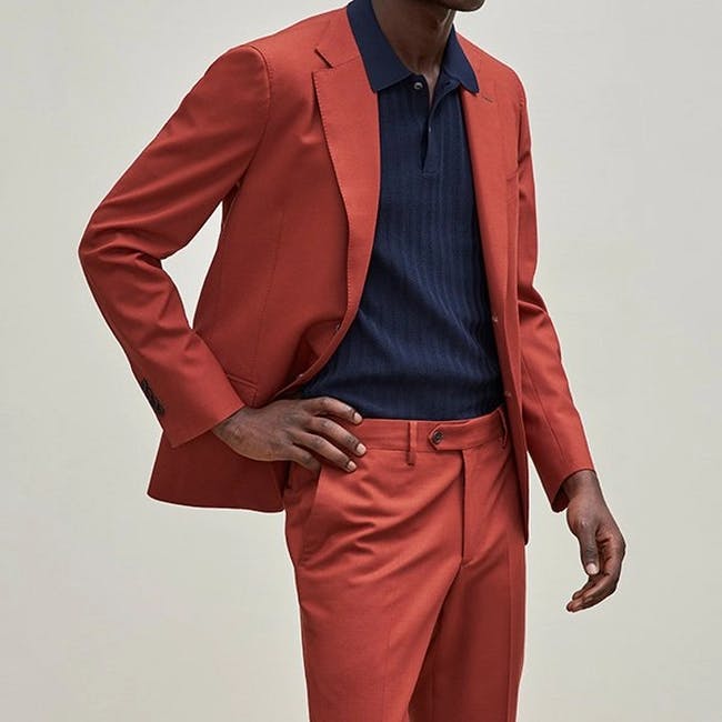 male model with hand on hip wearing matching suit and contrast polo