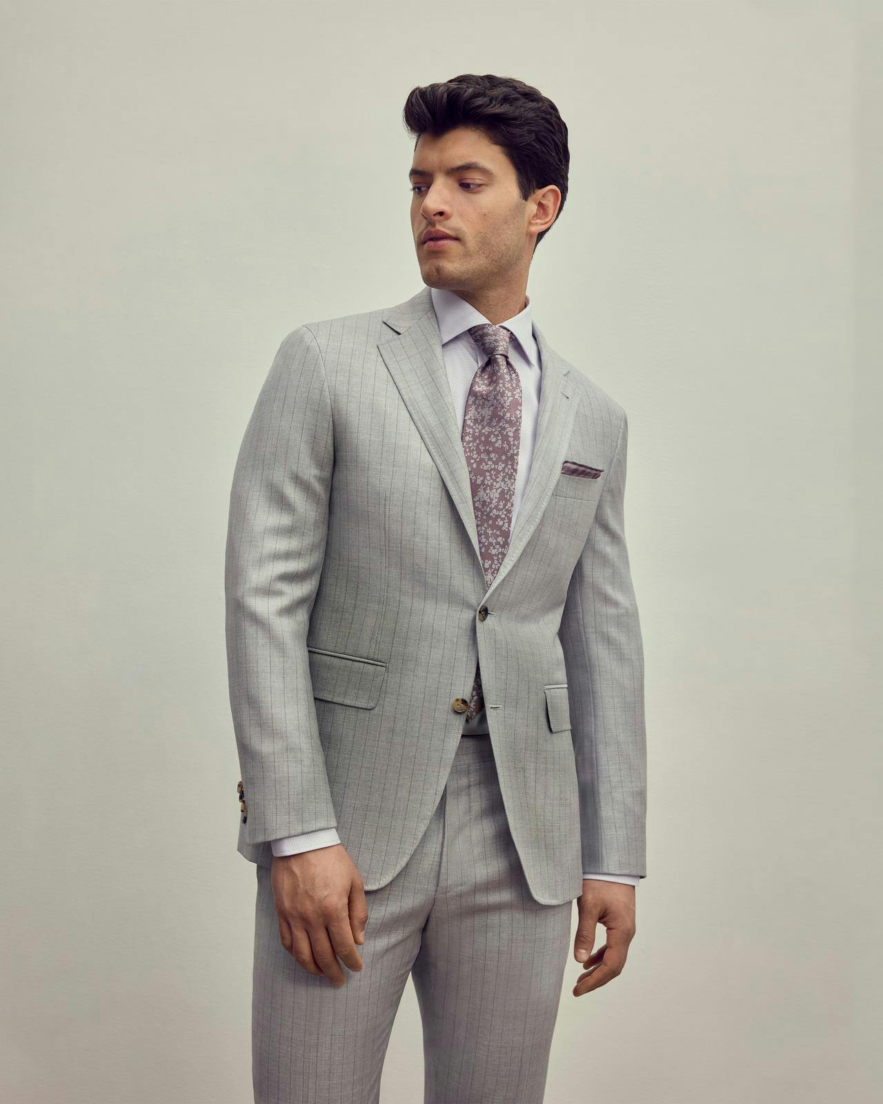a male model in a light grey suit and pink tie