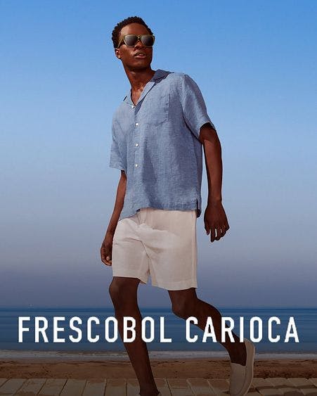 male model walking boardwalk wearing frescobol shorts and sport shirt