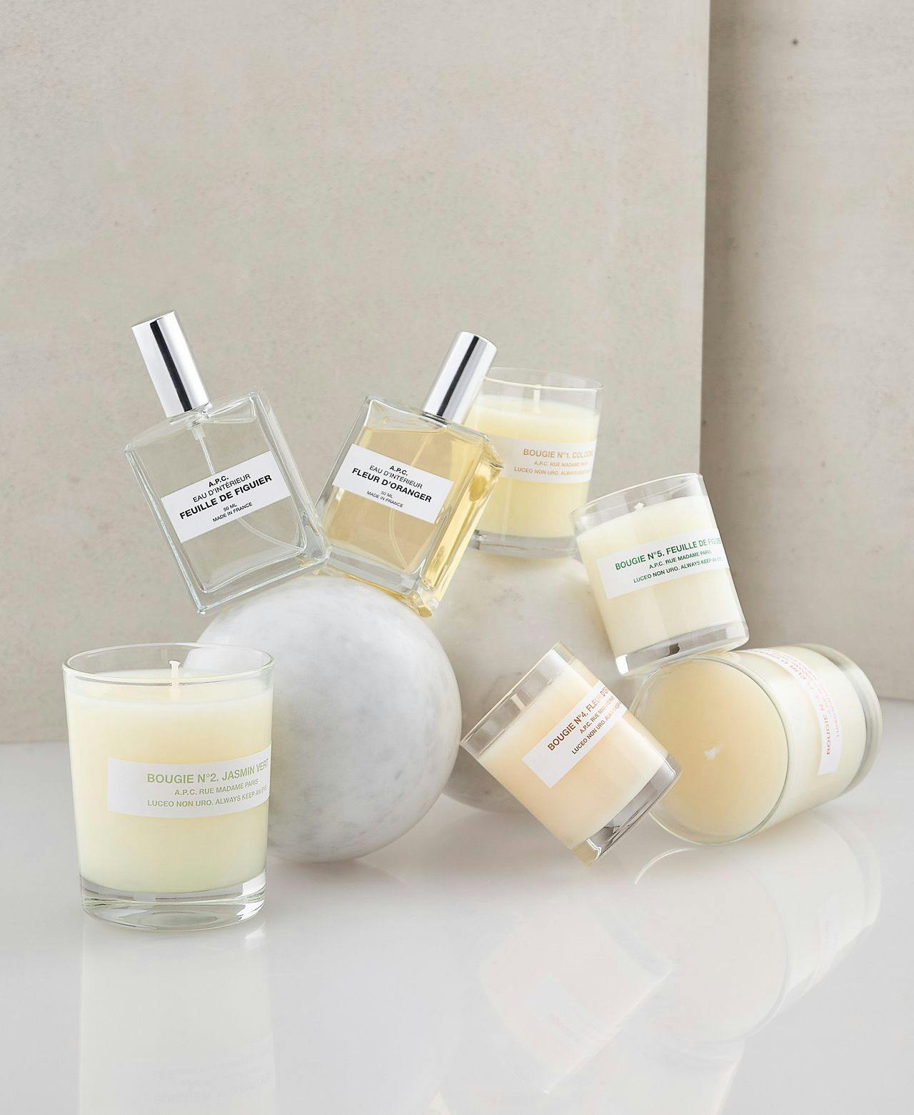 fragrances and candles on cream backrdop
