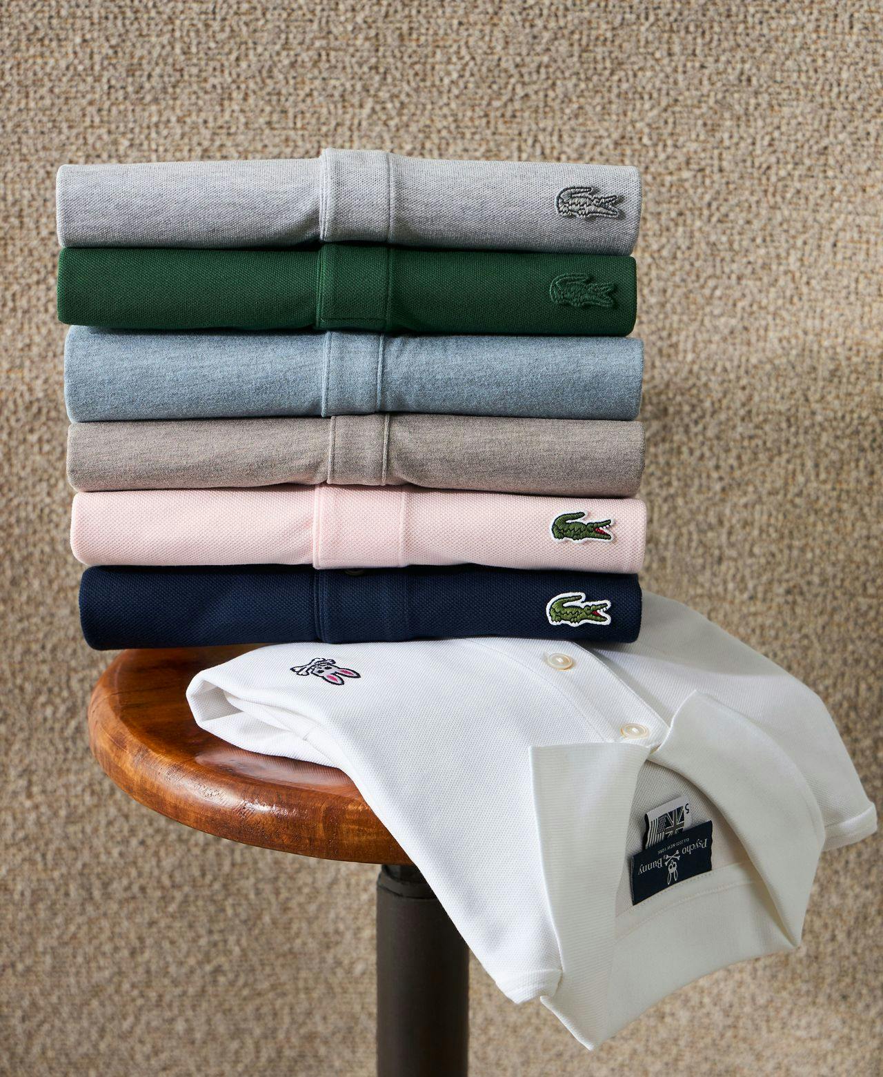 six different coloured polos folded on a side table and on one hanging off table