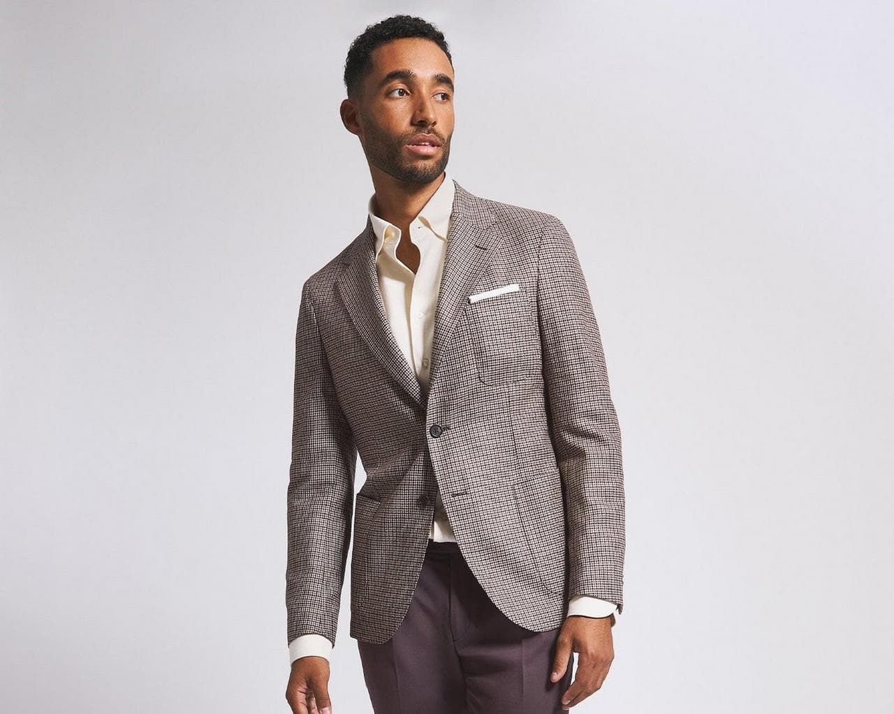 Two male models wearing suits on grey backdrop