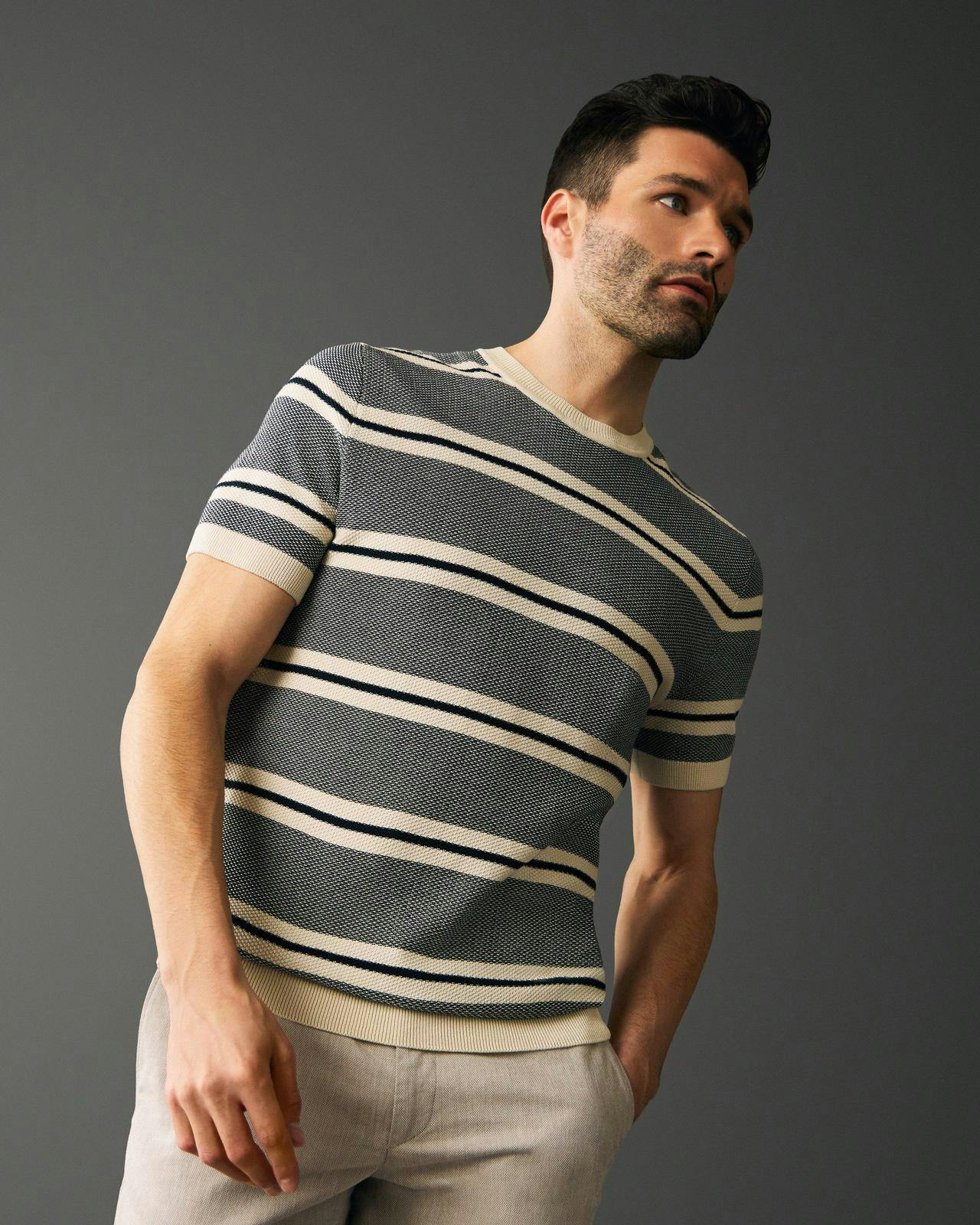 un homme dans un t-shirt rayé se penchant en arrière