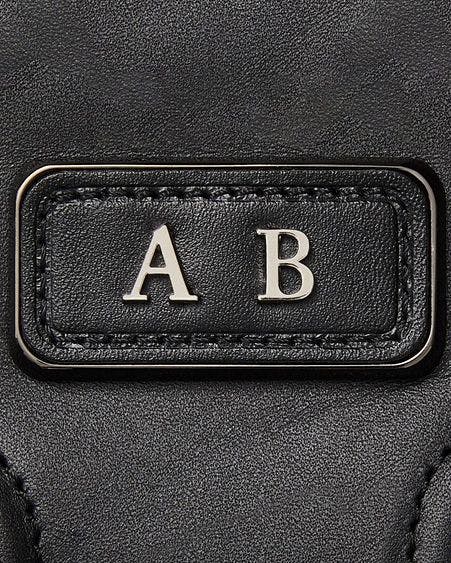 les initiales monogrammées sur un sac en cuir noir
