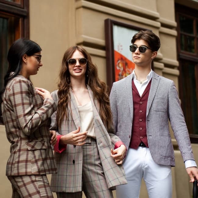 three associates mingling in the city wearing sport jackets and dress pants