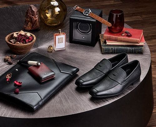 Une table avec une paire de chaussures, un portefeuille et une montre
