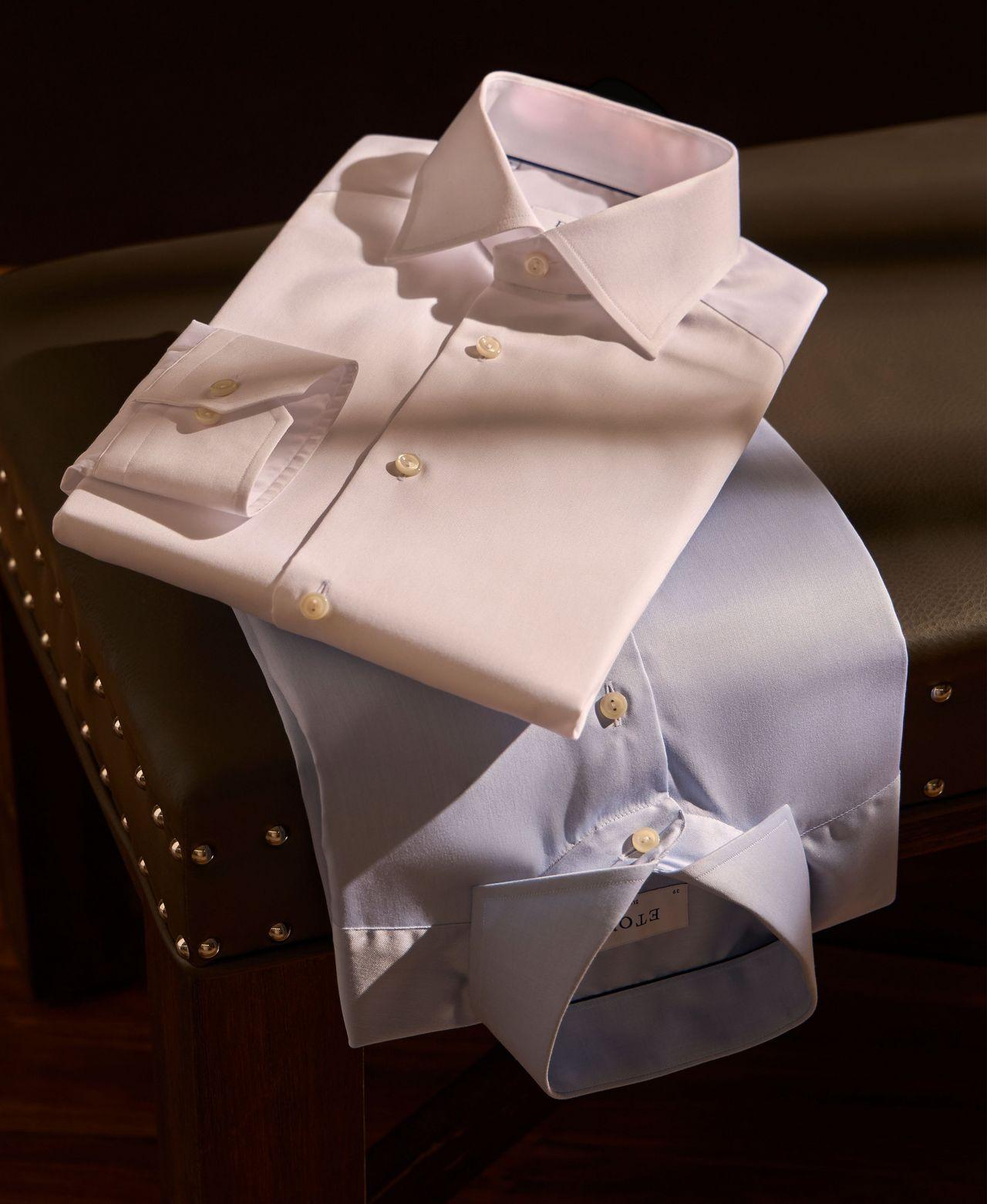 two dress shirts folded on stool