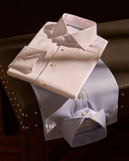 two dress shirts folded on stool