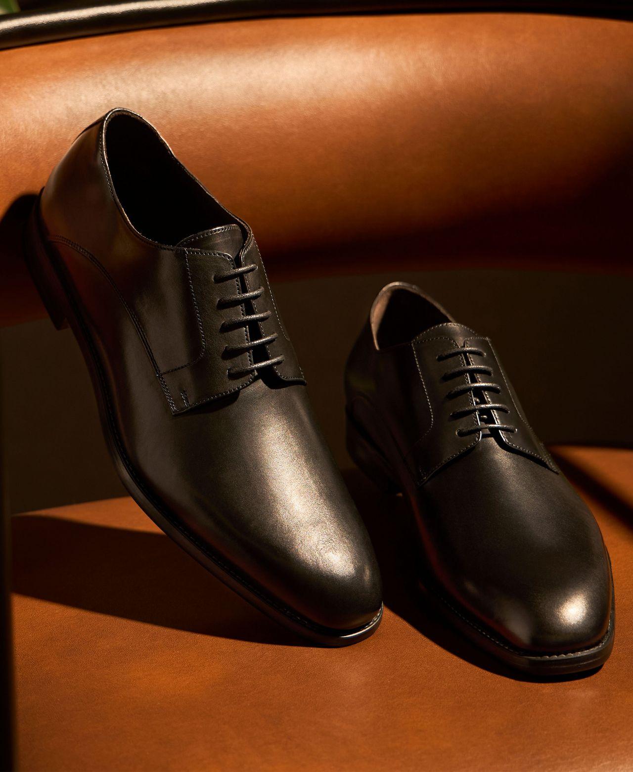 pair of dress shoes displayed on couch