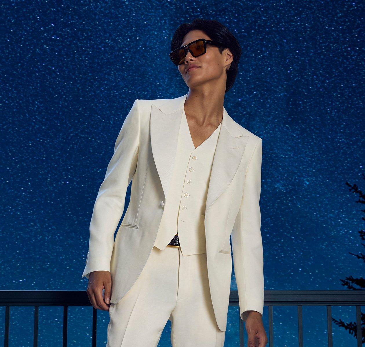 man wearing white suit with stars in background