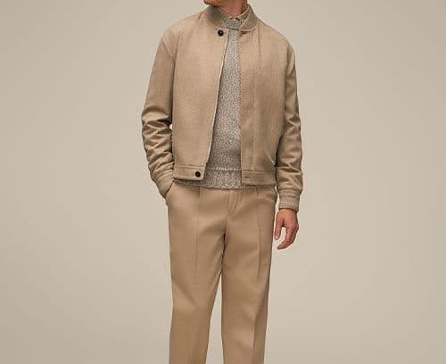 A man wearing tan suit and sneakers dresssed for the office in business casual clothing