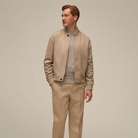 A man wearing tan suit and sneakers dresssed for the office in business casual clothing