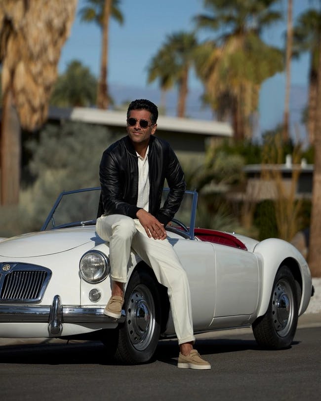 a man sitting on a white car in palm springs