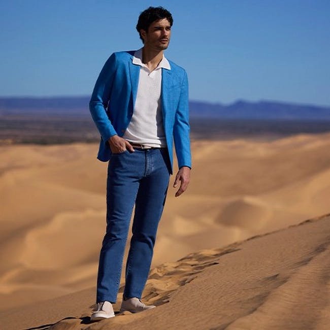 Un homme en veste bleue debout dans le désert