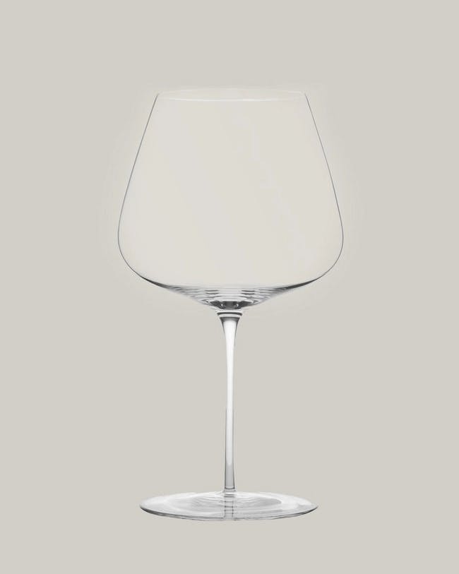 A wine glass with a stem on a gray background
