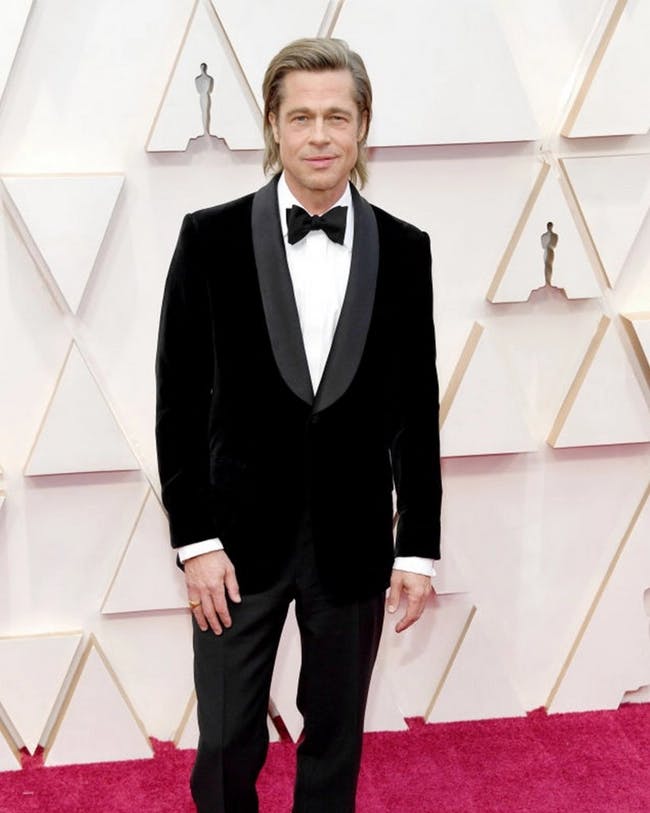 Brad Pitt in a tuxedo standing on the 2020 Oscars red carpet